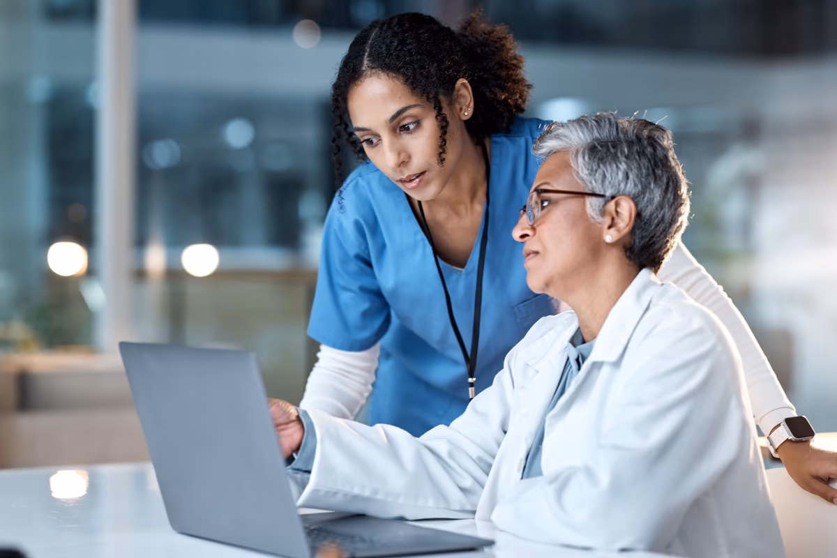 Two clinicians reviewing a patient record together on screen