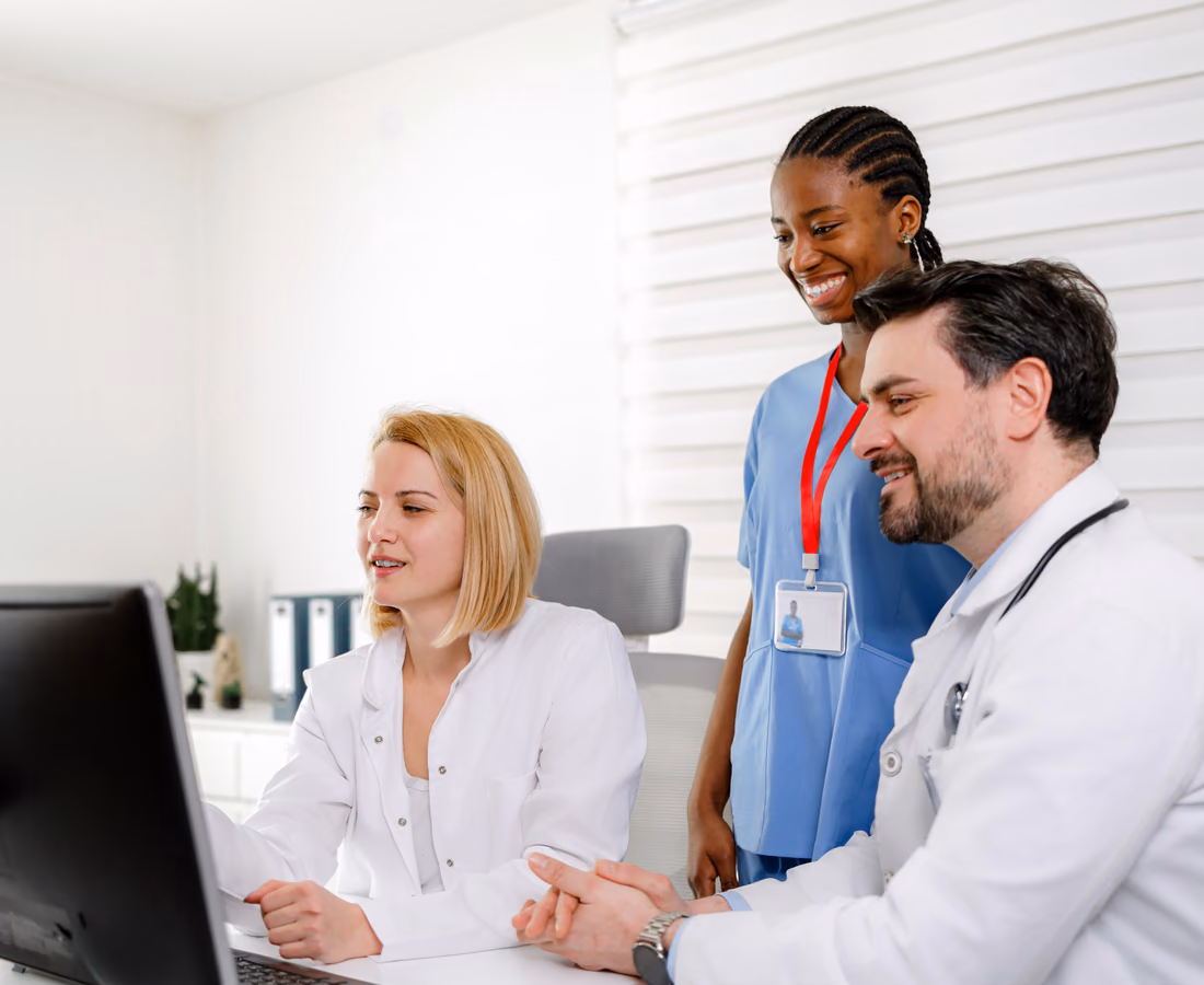 Three clinicians working together at a shared workstation